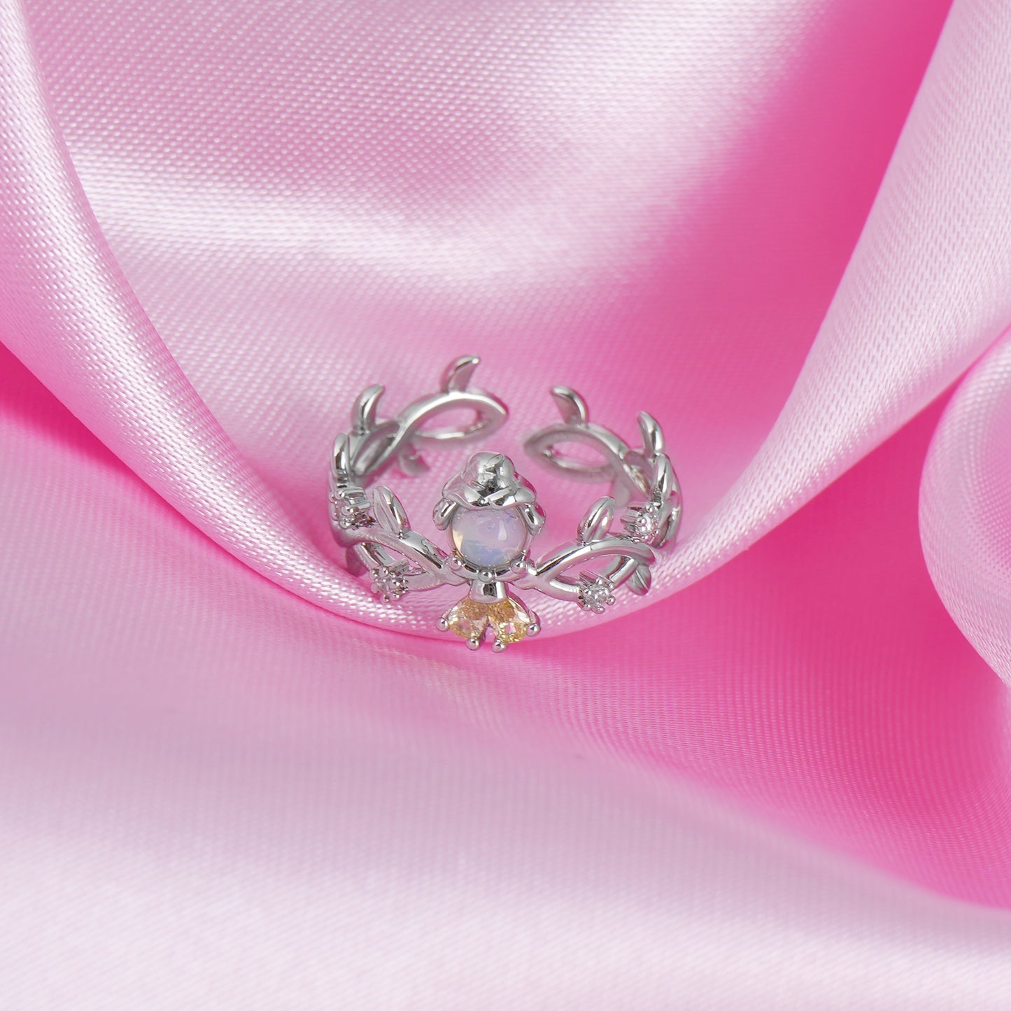 Silver Belle ring with a central gemstone on pink satin fabric