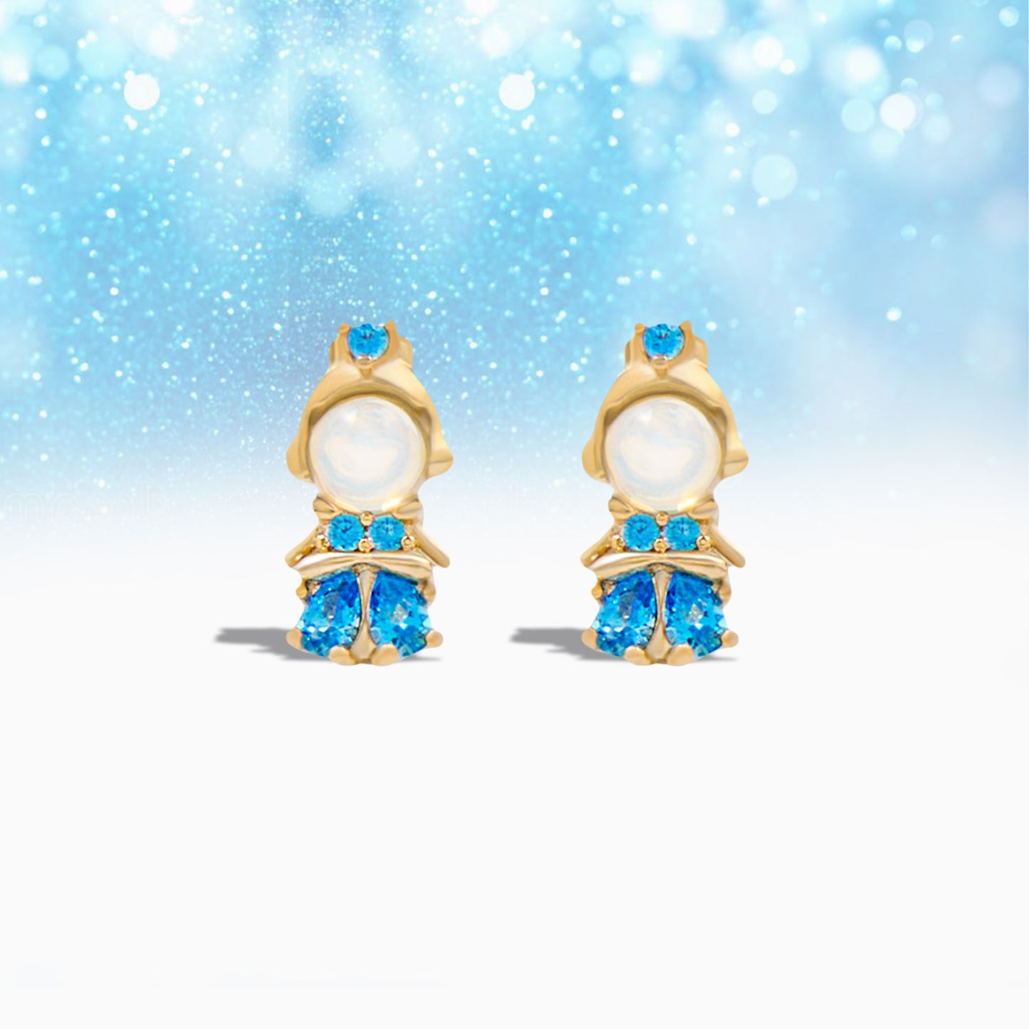 Pair of gold Princess Cinderella Earrings with blue gemstones on a light blue background