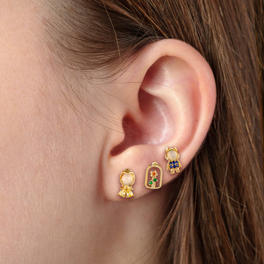 Close-up of an ear wearing gold Beauty and the Beast earring set
