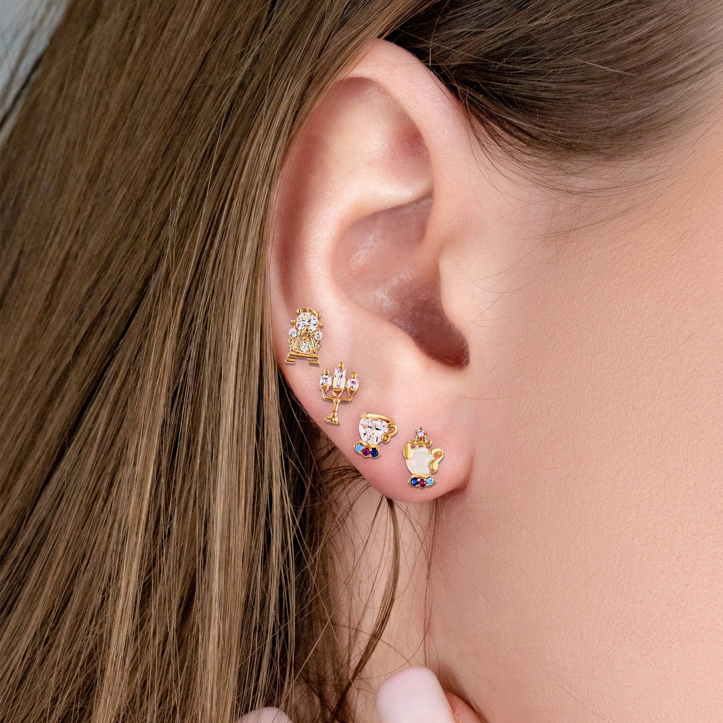 Close-up of an ear wearing Enchanted Objects gold earring set.