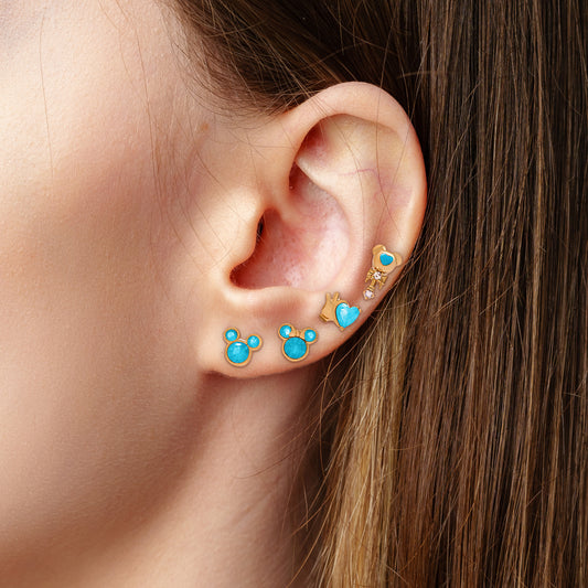 Close-up of an ear wearing gold Mickey & Minnie Blue Studs.