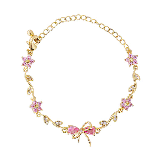 Gold bow bracelet with pink gemstones on a white background