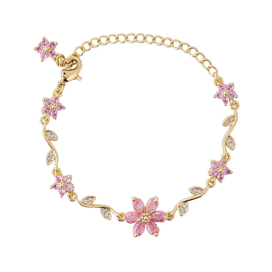 Gold bracelet with pink floral charms on a white background