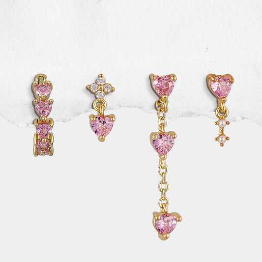 Set of gold and pink heart-shaped earrings on a white background