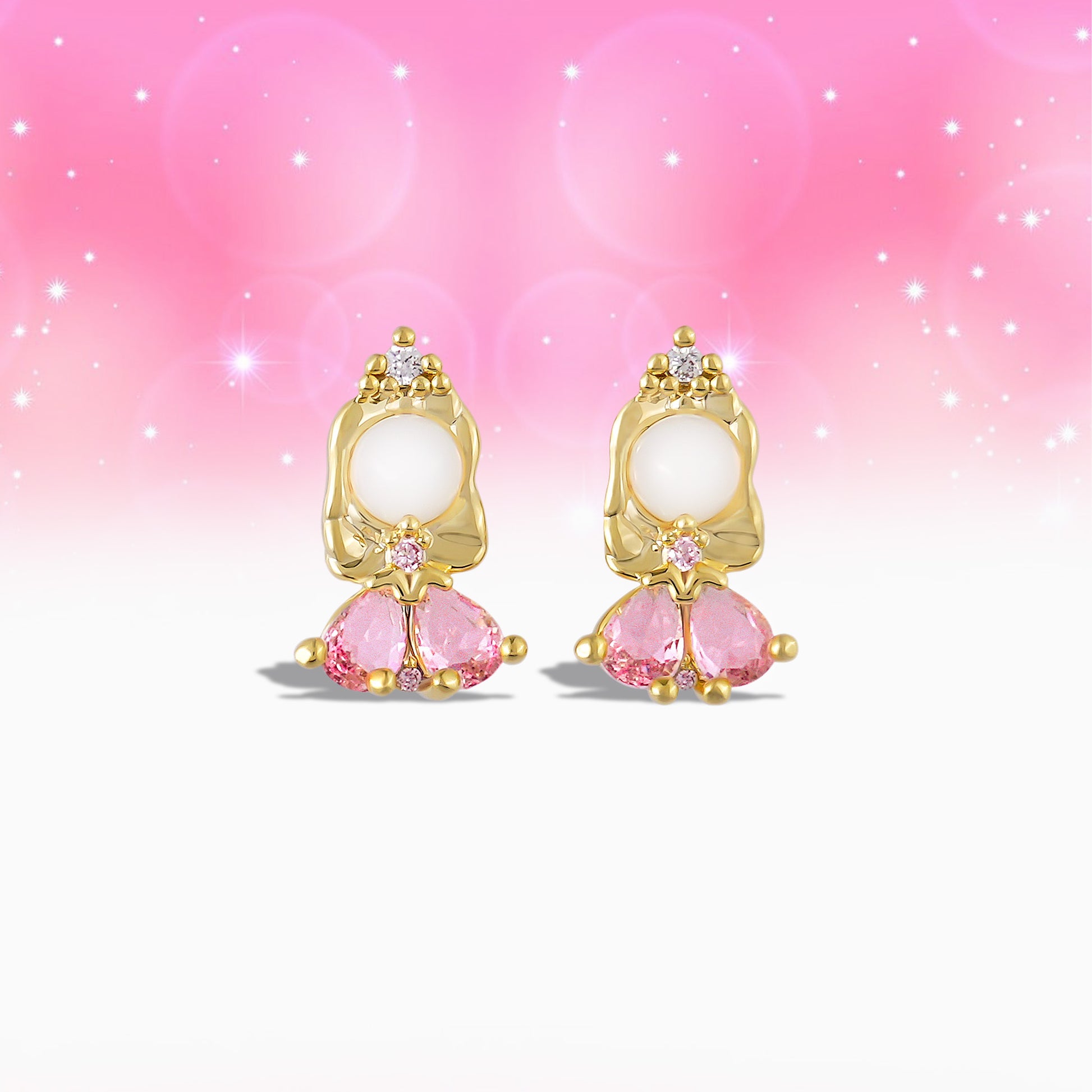 Pair of gold Princess Aurora earrings with pink gemstones on a gradient pink background