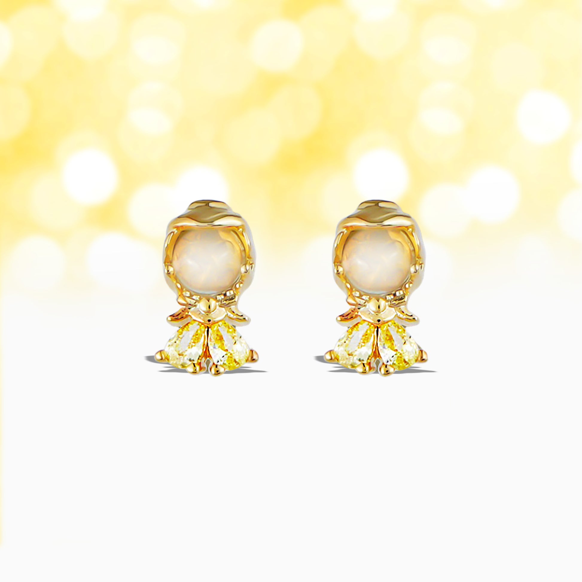 Pair of gold Princess Belle earrings with pearl-like centers on a yellow background