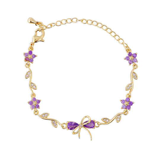 Gold bow bracelet with purple gemstones on a white background