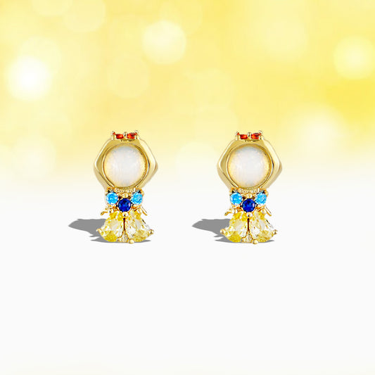 Gold Snow White earrings with pearls and gemstones on a yellow background