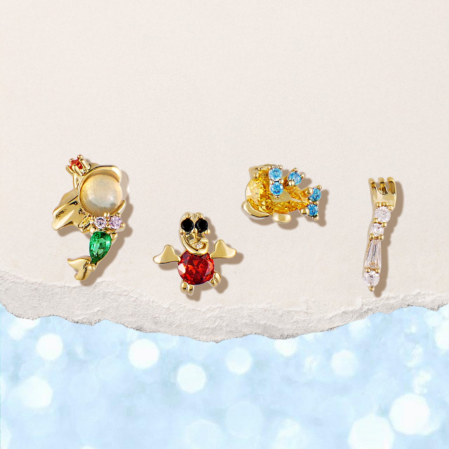 The Little Mermaid gold earring set on a light background