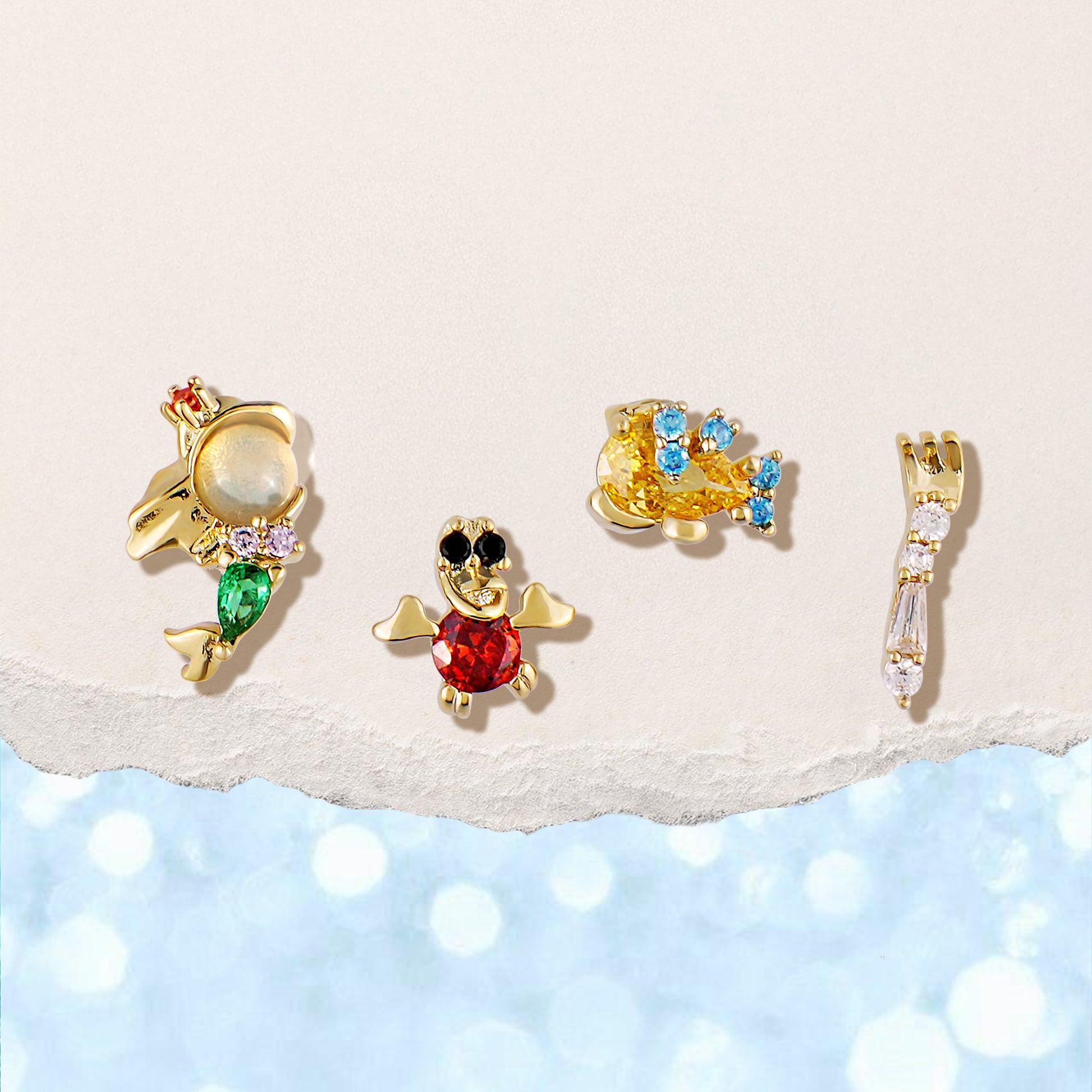 The Little Mermaid gold earring set on a light background